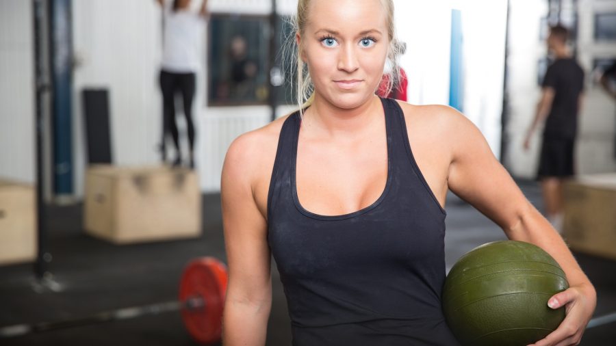 Fitness woman with slam ball at gym center